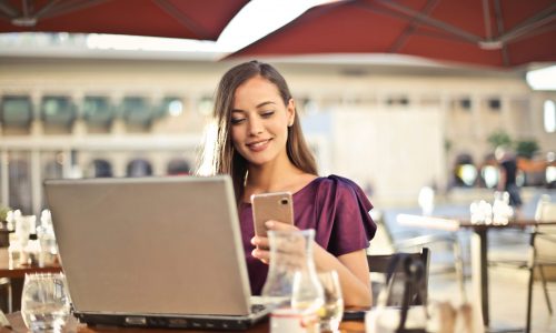 woman-wearing-purple-shirt-holding-smartphone-white-sitting-826349